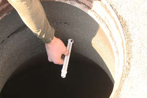 A tool used to check mortar thickness is inserted into uncured mortar