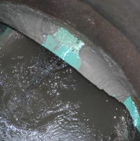 Leak in a concrete manhole between the concrete wall and sewer pipe
