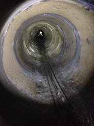 View down a corroded horizontal concrete culvert pipe